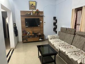 ein Wohnzimmer mit Sofa und Fernseher in der Unterkunft Tulips villa in Mānantoddy