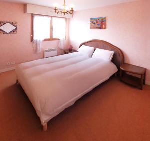 a large white bed in a bedroom with a window at Le Kervenel - Les Gîtes de la Côte d'Amour in Le Croisic +8 photos