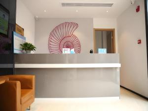 a lobby with a reception desk with a red shell on the wall at Shell Nanjing Jiangning District University City Hotel in Chunhua