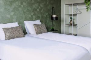 Una cama blanca grande con dos almohadas encima. en Modern Suite Near Raamsdonksveer Center, en Geertruidenberg