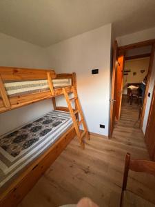 een slaapkamer met 2 stapelbedden en een eetkamer bij L'Atelier du Temps - Il Sogno di GI in Courmayeur
