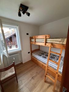 twee stapelbedden in een kamer met een raam bij L'Atelier du Temps - Il Sogno di GI in Courmayeur