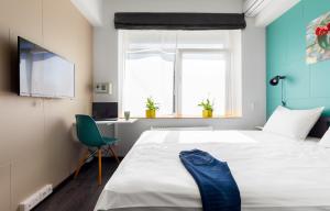um quarto com uma cama e uma cadeira e uma televisão em Live hotel by Original Hotels em Ecaterimburgo