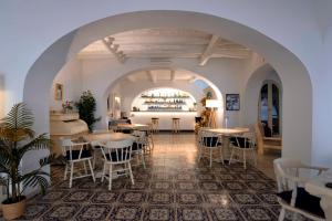 Un restaurante con mesas y sillas en una sala. en Pietra Pomice Hotel, en Lipari