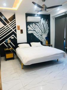 een slaapkamer met een bed met een schilderij aan de muur bij Luxury Manzil in Lahore