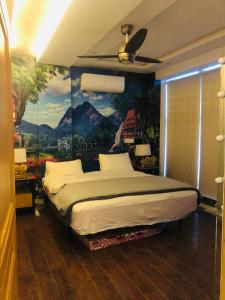 een slaapkamer met een groot bed met een schilderij aan de muur bij Luxury Manzil in Lahore