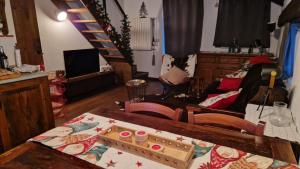 ein Wohnzimmer mit einem Tisch und einer Treppe in der Unterkunft ComBaita alle porte del cielo in Pragelato