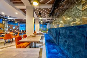 Un restaurante con mesas y sillas y una pared azul. en Tomy Forest Cigar Bar, en Ocka Gora