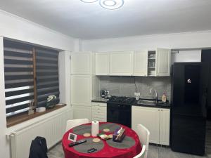 a kitchen with a red table and a black refrigerator at Central VIP in Craiova +3 photos