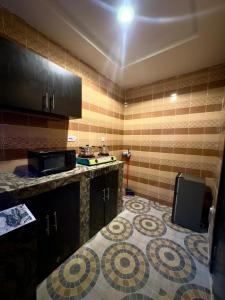 a kitchen with a counter and a tile floor at Tway Apartments in Ilorin