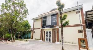 a building with a palm tree in front of it at OYO Life 2735 Graha Nirwana in Bokor