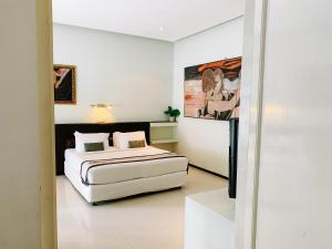 a bedroom with a bed and a painting on the wall at Casa Artista By Kresna Hospitality in Seminyak