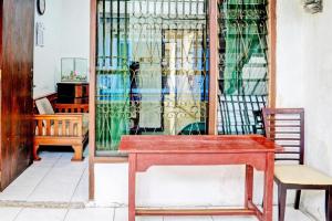 a room with a table and a dog in a window at SPOT ON 93475 Garuda Homestay Syariah in Sukabumi