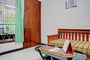 a room with a bed and a table with a laptop on it at SPOT ON 93475 Garuda Homestay Syariah in Sukabumi