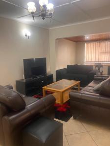 a living room with couches and a coffee table at Tesco Accommodation in Gqeberha