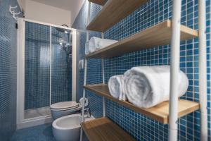 Un baño con azulejos azules, inodoro y lavabo. en Amazhome - Il nido nella quiete del Titano, en San Marino 44 fotos más
