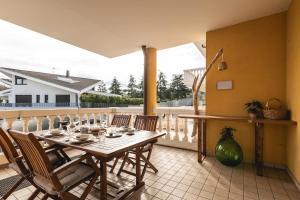 Un comedor con mesa y sillas en un balcón. en Amazhome - Il nido nella quiete del Titano, en San Marino