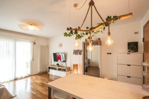 Una sala de estar con una mesa y un televisor. en Amazhome - Il nido nella quiete del Titano, en San Marino