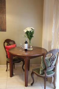 a table with a bottle of wine and flowers on it at Tiffany's Apartment in Las Palmas de Gran Canaria