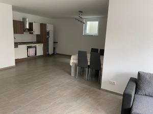 a living room with a table and chairs and a kitchen at FK1 Moderne 75qm 2 Zimmer Einliegerwohnung in Königsbronn