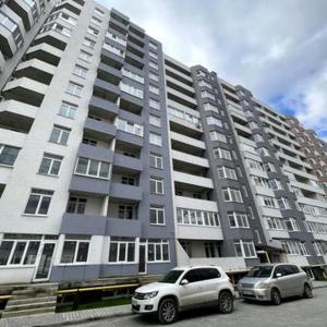 dois carros estacionados em frente a um grande edifício em Soft Loft ЖК Київський em Ternopil