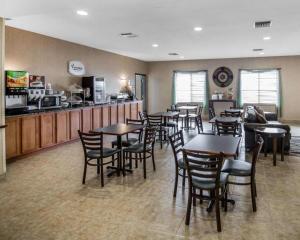 a restaurant with tables and chairs and a kitchen at Rodeway Inn & Suites Salina South in Salina
