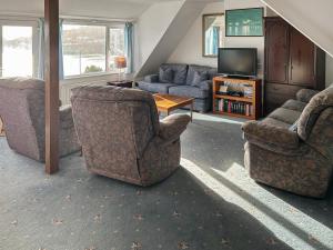 a living room with two chairs and a television at The Anchorage in Coverack