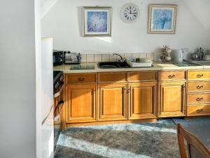 a kitchen with wooden cabinets and a sink at The Anchorage in Coverack
