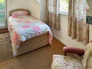 a small bedroom with a bed and a chair at The Anchorage in Coverack +4 photos