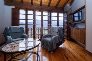 a living room with two chairs and a glass table at La Casina del Alba in Campiellos