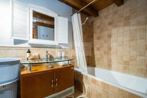 a bathroom with a sink and a bath tub at La Casina del Alba in Campiellos