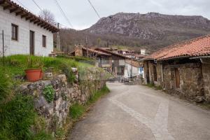 an empty street in a village with a mountain at La Casina del Alba in Campiellos