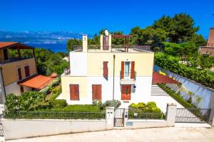 una casa blanca en una colina con el océano en el fondo en Villa Big View, en Splitska