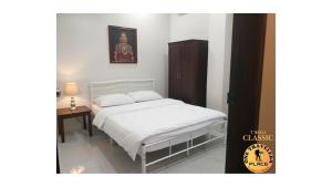 ein Schlafzimmer mit einem weißen Bett und einem Tisch in der Unterkunft One Travelers Place in Koronadal + 4 Fotos