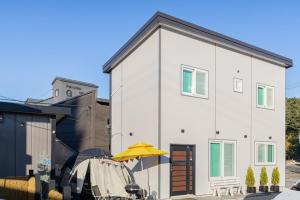 a white house with a yellow umbrella in front of it at Gangneung SH Pension in Gangneung +2 photos
