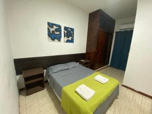 ein kleines Schlafzimmer mit einem Bett und einem Tisch in der Unterkunft Hotel Oscar in Maracaibo