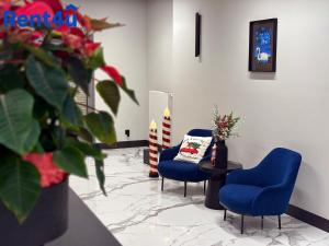 a waiting room with two blue chairs and a table at Nad Zatoką Aparthotel by Rent4You in Olsztyn
