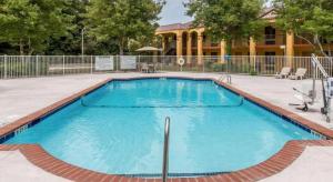 a large swimming pool with blue water in front of a house at Econo Lodge Dalton West in Dalton