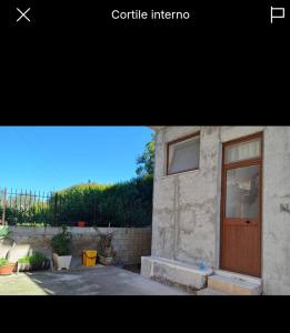a picture of a building with a wooden door at Florina Appartment in Capo dʼOrlando