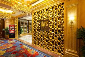 a lobby with a gold wall with a sign on it at StarWorld Hotel in Macau