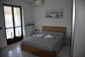 a bedroom with a bed with two towels on it at A casa di Gina in Airasca