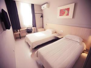 a hotel room with two beds and a window at Jinjiang Inn Changchun Pepole Square in Changchun +55 photos