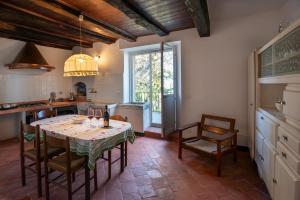 une cuisine avec une table et des chaises dans une cuisine dans l'établissement Casa Dolcetto, à Tagliolo Monferrato