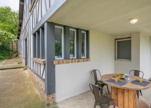 eine Terrasse mit einem Tisch und Stühlen neben einem Gebäude in der Unterkunft Nou Kontan vwe zot in Abbecourt