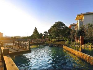 a small river with a bridge in a park at Quanzhou Guest House Hotel in Quanzhou