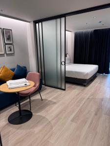 ein Zimmer mit einem Bett, einem Tisch und einem Stuhl in der Unterkunft Luxury Studio, 1 Bed, Separate Study Gourmet Kitchen Prime Location in Bangalore