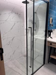 eine Glasdusche im Bad mit Waschbecken in der Unterkunft Luxury Studio, 1 Bed, Separate Study Gourmet Kitchen Prime Location in Bangalore + 8 Fotos