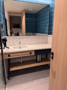 ein Badezimmer mit Waschbecken und großem Spiegel in der Unterkunft Luxury Studio, 1 Bed, Separate Study Gourmet Kitchen Prime Location in Bangalore