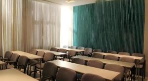 a room with tables and chairs and a green wall at Jinjiang Inn Changchun Pepole Square in Changchun