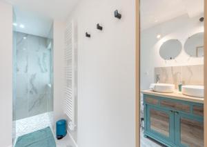 ein Bad mit 2 Waschbecken und einer Dusche mit Spiegeln in der Unterkunft Nou Kontan vwe zot in Abbecourt